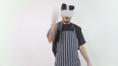 Şef, sanal gerçeklik kulaklığı takıyor. Kontrolörleri kullanıyor ve elleriyle kesiyor.