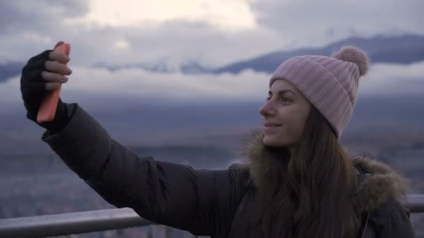 Женщина делает селфи на балконе высотки — стоковое видео