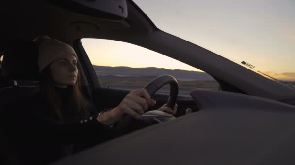 Mujer feliz con sombrero de pompón de invierno bailando y conduciendo coche, yendo a casa para las vacaciones — Vídeos de Stock
