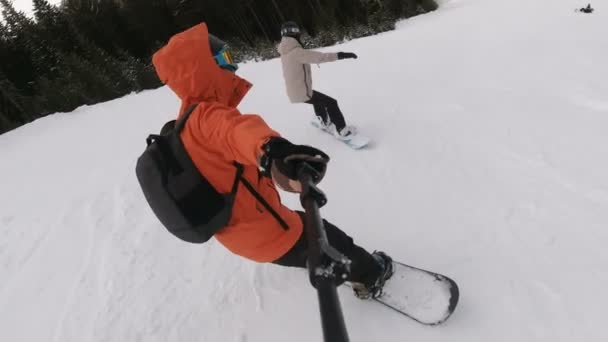 Pareja joven Snowboard en la estación de esquí, Mujer cayendo en la nieve — Vídeos de Stock