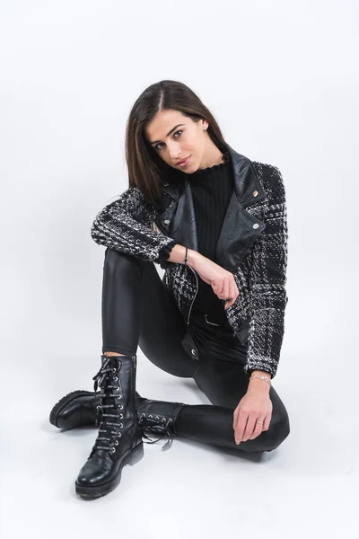 Portrait de Belle femme en cuir noir pantalon et bottes hautes assis — Photo