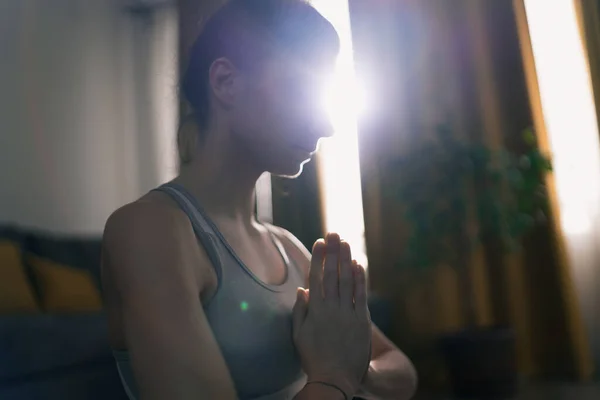 Primer plano de mujer concentrada meditando por la mañana con el sol brillando a través de la ventana — Foto de Stock