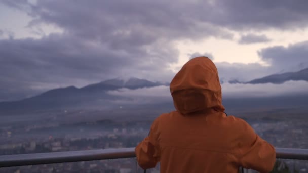 Visão traseira do homem assistindo vista celestial da cidade de Razlog e montanhas enevoadas — Vídeo de Stock