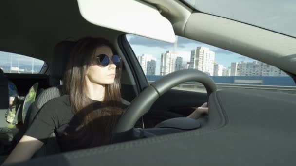 Enfocado mujer joven conduciendo coche en carretera de la ciudad — Vídeo de stock