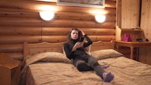 Jovem assistindo TV e descansando dentro de uma cabine de madeira durante o inverno — Vídeo de Stock