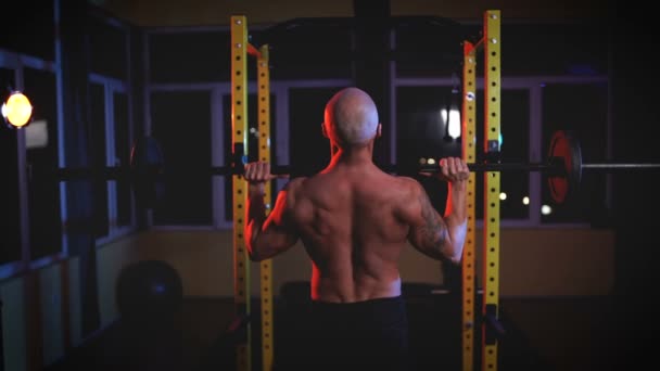 Berat pria berkaos berkeringat mengangkat dengan barbel di gym, melihat ke belakang — Stok Video