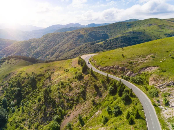 Vedere aeriană a urmăririi unui camion și a două mașini pe drumul de trecere montană cu pădure frumoasă Fotografie de stoc