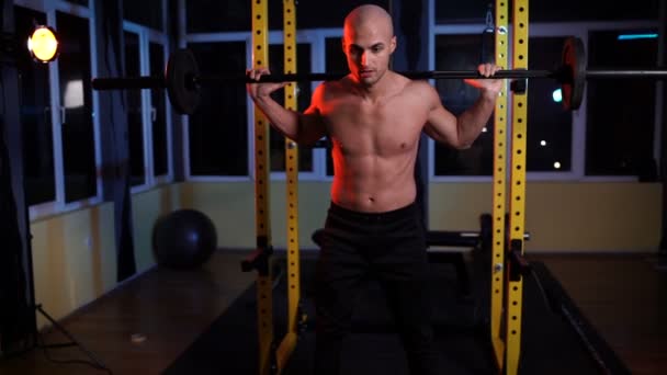 Hombre haciendo sentadillas usando jaula en cuclillas en un gimnasio — Vídeos de Stock