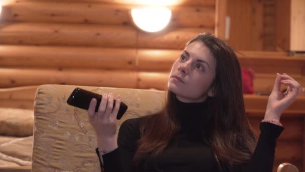 Vedere atentă a femeii cu telecomandă în joc de mână cu părul — Videoclip de stoc
