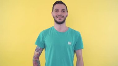 Mutlu, genç, sportif adam başparmağını kaldırıyor.