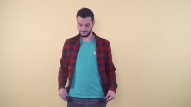 Расстроенный человек в повседневной одежде, которая показывает пустые карманы — стоковое видео
