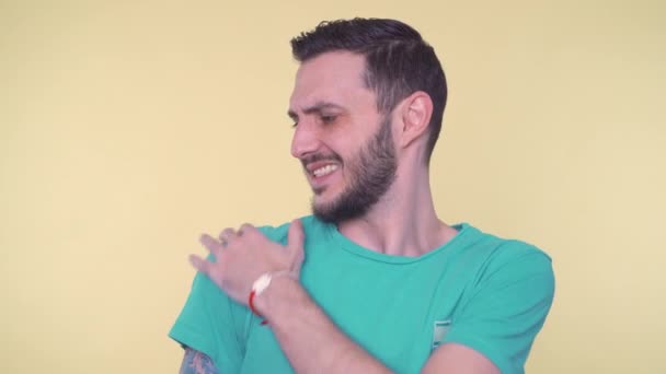 Gestresste man met pijn van schouder letsel, proberen om het te verlichten door bewegende arm — Stockvideo