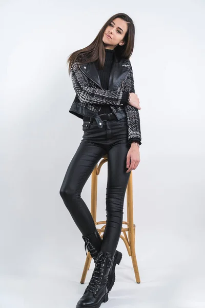 Charmante junge Frau in modischer Kleidung lehnt auf Stuhl — Stockfoto
