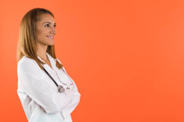 Beyaz önlük ve steteskop giymiş gülümseyen bir kadın doktor ya da hemşire portresi