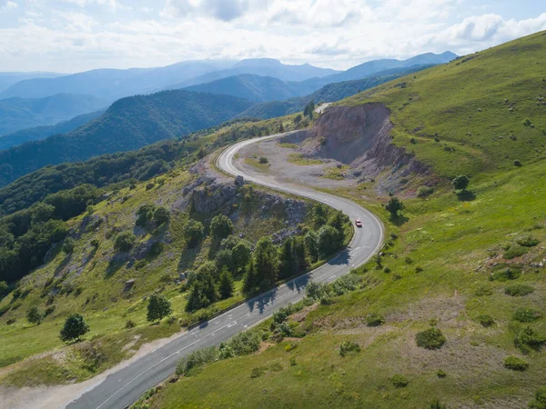Yazın virajlı dağ yolunda araba sürüşünün havadan görüntüsü — Stok fotoğraf