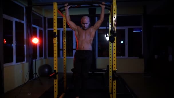 Culturista haciendo ejercicios abdominales intensos tarde en la noche en el gimnasio — Vídeos de Stock