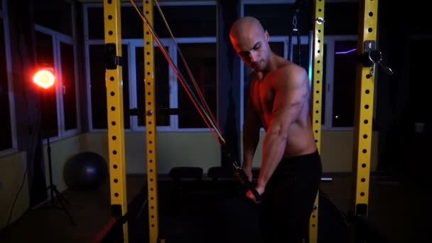 Pria binaragawan pelatihan dengan band resistensi untuk triceps di gym — Stok Video