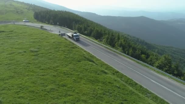 Drona urmărește un camion de transport mare pe un drum de munte — Videoclip de stoc