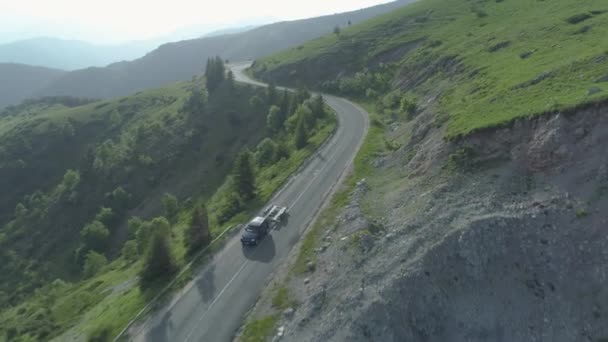 Drohne verfolgt schwarzen Geländewagen, der leeren Anhänger auf Waldbergstraße schleppt — Stockvideo