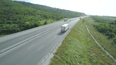 Büyük yük kamyonlarının yaz aylarında otobanda sürüşlerinin yavaş çekim görüntüleri.