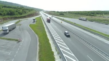 Trafikli Yaz Yolu 'nun Drone görüntüsü. Beyaz otobüs büyük bir nakliye kamyonunu geçiyor.