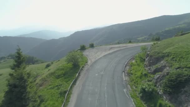 Drone perseguindo SUV com um reboque na estrada de montanha sinuosa — Vídeo de Stock