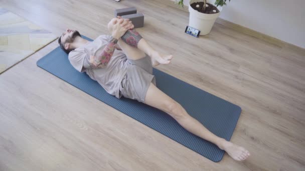 Ajuste o homem na dose do Yoga do vento-relevo em casa — Vídeo de Stock