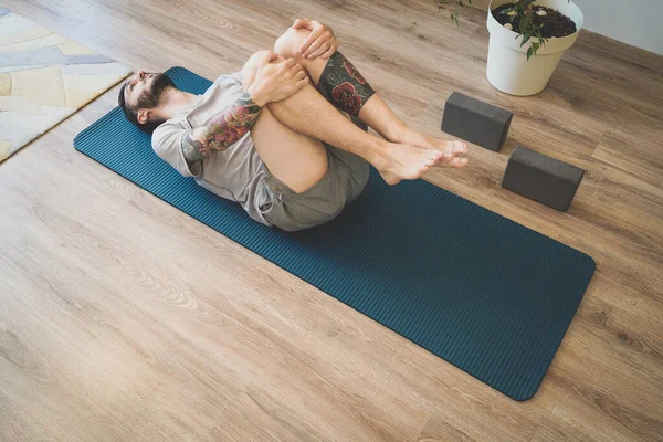 Un tânăr care începe ziua cu Wind-Relieving Pose acasă Imagini stoc fără drepturi de autor