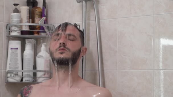 Γενειοφόρος άνδρας με κλειστά μάτια που κάνει ντους το πρωί — Αρχείο Βίντεο