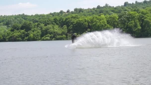 Wakeboarder a kábelen, hogy egy nagy csobbanás után ugrás, lassított felvétel — Stock videók