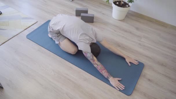 Jovem barbudo homem em criança ioga pose Balasana — Vídeo de Stock