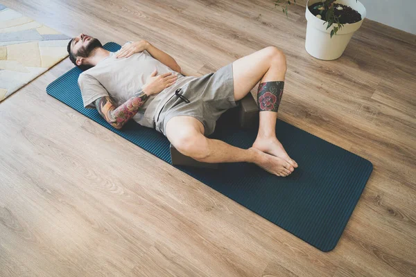 Hombre joven haciendo ejercicio de respiración diafragmática para una relajación profunda Fotos De Stock Sin Royalties Gratis