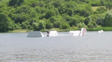 Genç bir adam rampada zıplıyor ve ön ve arka taklalar atıyor.