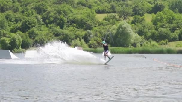 Ekstrem wakeboardcunun yavaş çekim görüntüsü numara yapıyor ve suya düşüyor — Stok video