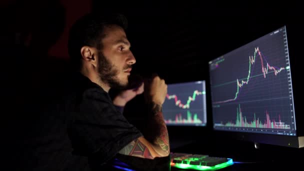 Stock market trader looking at graphs and analyzing them on multiple monitors — Vídeo de Stock