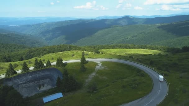 Drone following white cargo van driving on a mountain road with beautiful green mountains — Vídeo de Stock