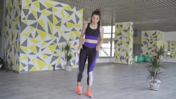 Kvinnlig tabatatatatatränare som visar hur man sträcker på benen innan intensiv träning — Stockvideo