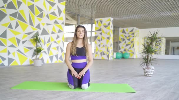 Athletic kvinnliga tabata coach knäböja på grön matta i gym gör online fitness klass — Stockvideo