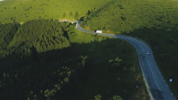 Camion da carico e guida in auto su una strada tortuosa in collina, vista dall'alto — Video Stock