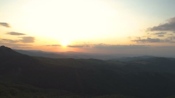 Wędrowiec górski z mapą odpoczywający o zachodzie słońca, siedzący na szczycie góry i cieszący się zachodem słońca — Wideo stockowe