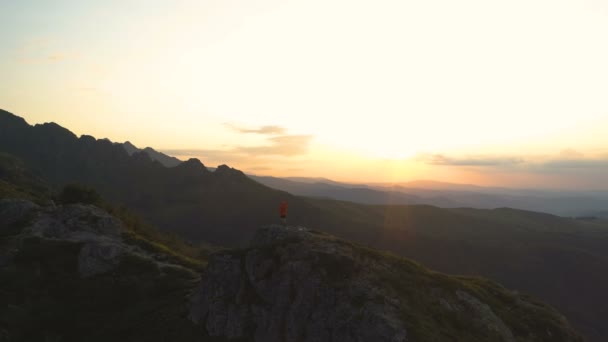 Randonneur en montagne avec sac à dos sur le sommet de la montagne avec vue panoramique sur les collines à couper le souffle au coucher du soleil — Video