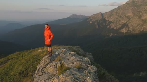 Resenär man sitter ensam vid klippbranten och tittar på den vackra solnedgången — Stockvideo