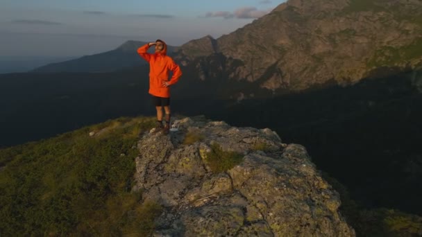Männlicher Tourist mit der Hand über den Augen mit Blick auf einen farbenfrohen Sonnenuntergang auf einem Gebirge in Bulgarien — Stockvideo