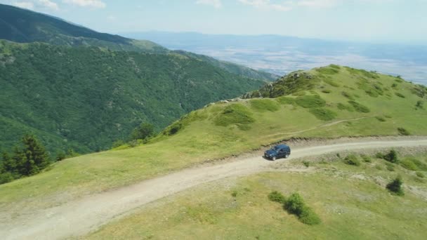 Blå fordon på kanten av en klippa med lera offroad spår i bergen — Stockvideo