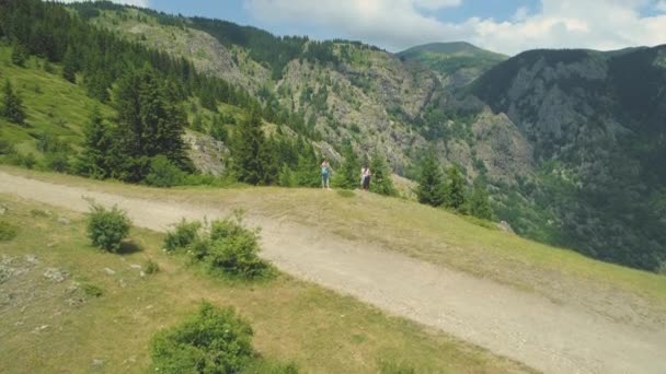 Vandrare tar bilder vid kanten av en kulle med vacker utsikt över dalen nedanför — Stockvideo