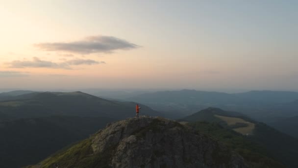 Junger Mann wandert auf felsigem Berg und liest Landkarte, mit Sonnenuntergang und tiefem Tal unten — Stockvideo