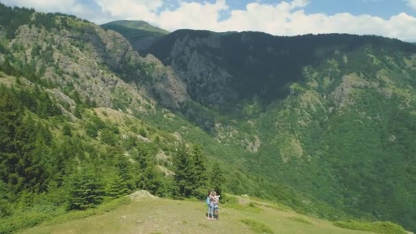 Preciosa pareja tomando fotos selfie en la cima de la montaña con valle profundo debajo — Vídeos de Stock