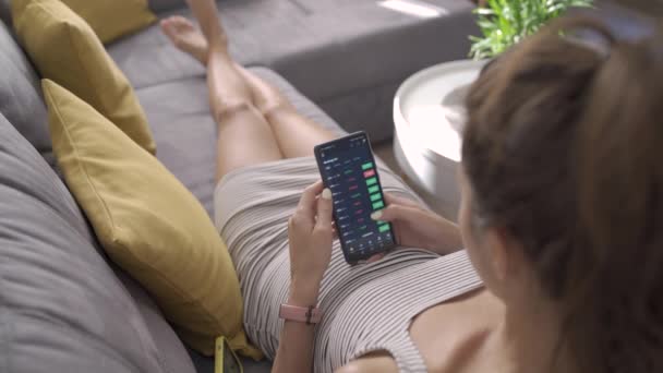 Sofia, Bulgaria-07 08 2021: women check crypto trading platform on smartphone relax at sofa — Stock Video