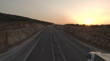 İHA, gün batımında bir otoyolda Long Haul Semi Truck 'ı takip ediyor.