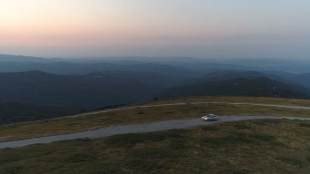 Luftaufnahme von Auto fahren auf Sonnenuntergang Bergstraße mit grünen Hügeln Tal und dramatischen Himmel — Stockvideo